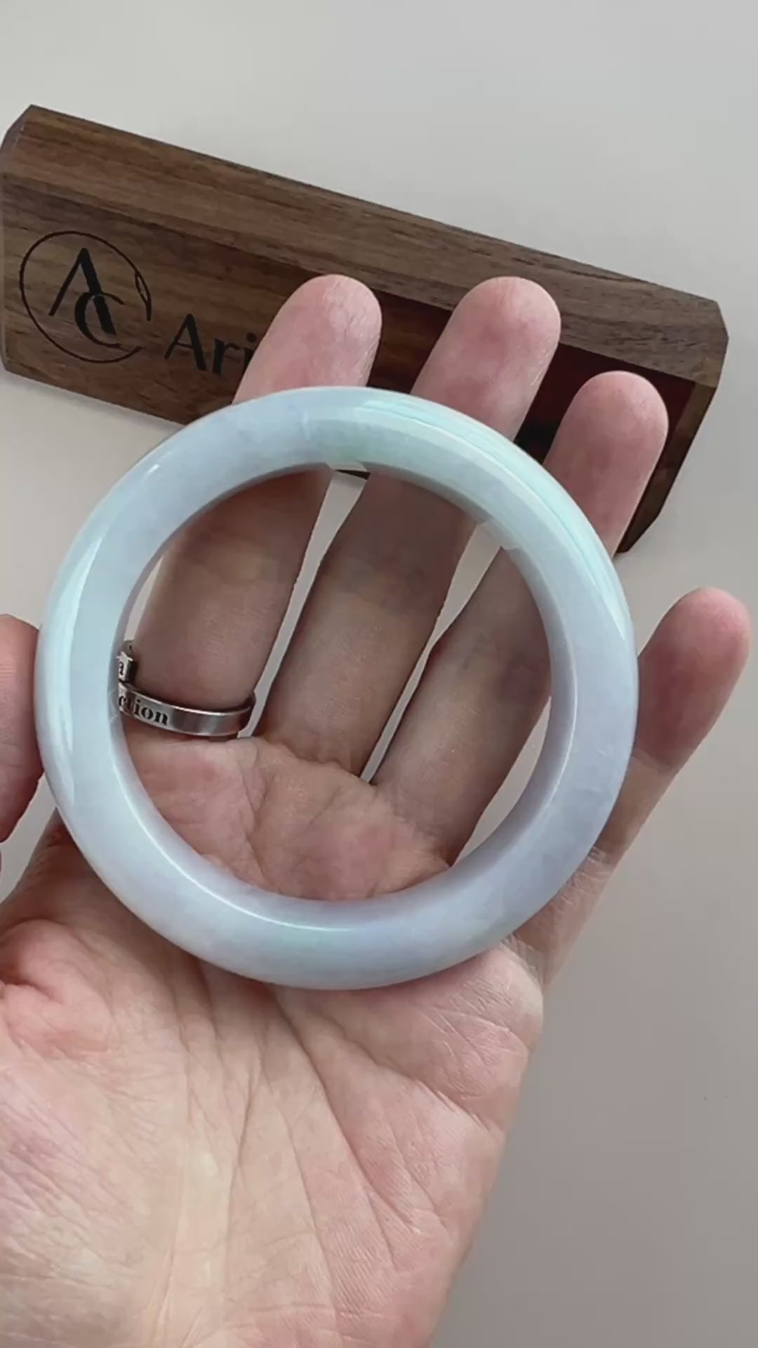Video of an icy light blue Burmese jadeite bangle with smooth polished surface and rounded classic profile