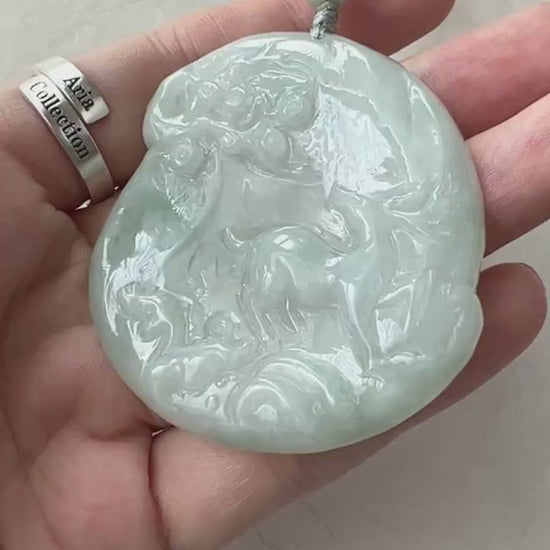 Video of a hand-carved green jadeite deer pendant with an elegant, organic forest scene design