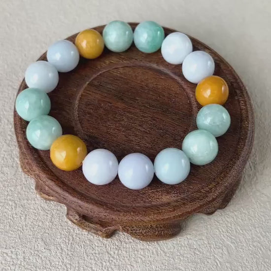 Video of hand-carved jadeite bracelet with 16 semi-translucent lavender, green, and yellow beads in an elegant style