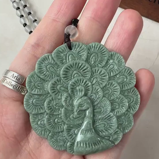 Video of a natural jade peacock pendant with fluid carved lines and decorative beaded necklace, elegant green luxury style