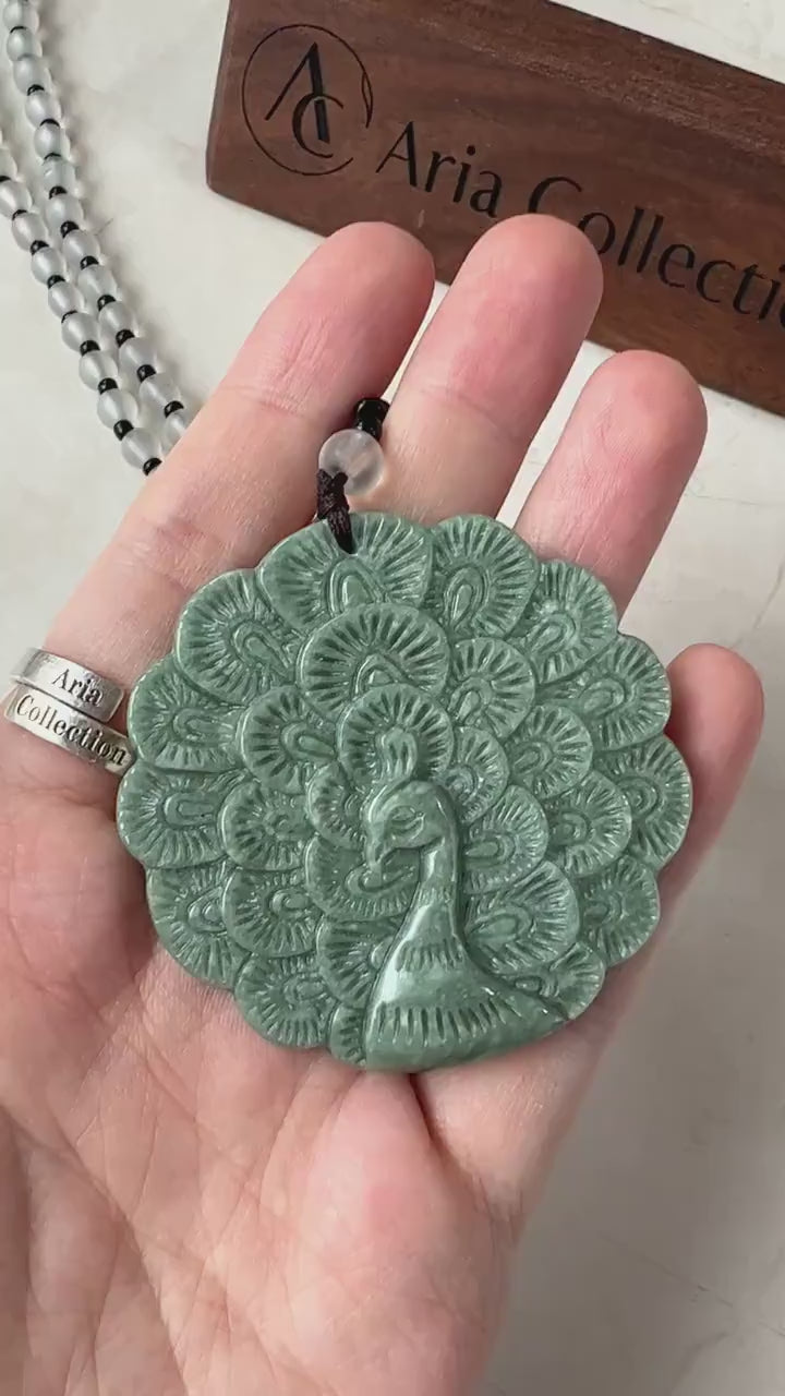 Video of a natural jade peacock pendant with fluid carved lines and decorative beaded necklace, elegant green luxury style