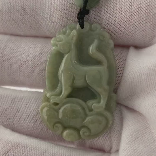 Video of a hand-carved natural jade Chinese Zodiac Dog pendant with unique green tones and artisanal detail