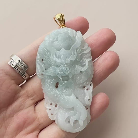 Video of an icy pale blue jadeite dragon pendant with openwork relief and 18k gold bail, polished and translucent