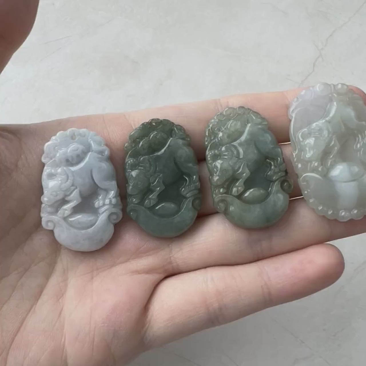 Video of a hand-carved natural jade Ox Zodiac pendant in green tones with an ingot detail, unique and elegant