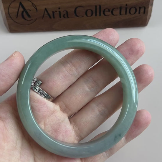 Video of a polished Burmese Type A jadeite bangle in soft light green-blue with a translucent, smooth classic form