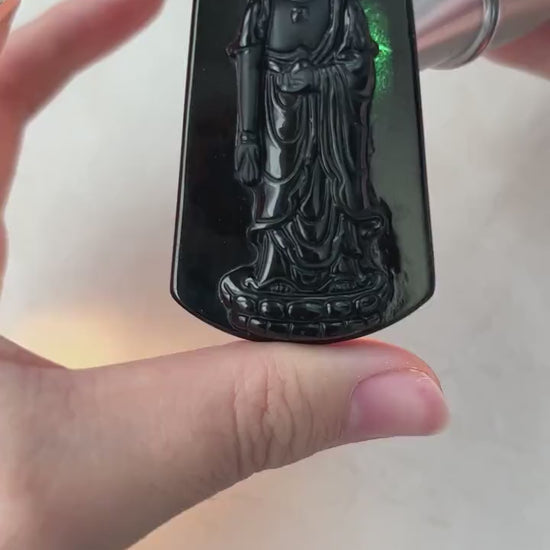Video of a hand-carved black jadeite Amitabha Buddha pendant with glossy oil-like sheen and subtle green glow