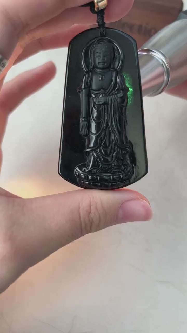 Video of a hand-carved black jadeite Amitabha Buddha pendant with glossy oil-like sheen and subtle green glow