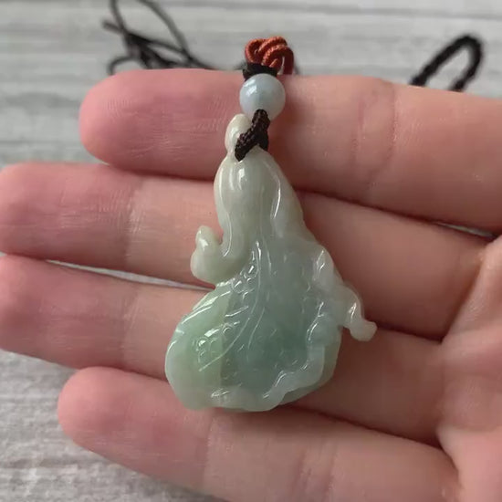 Video of a hand-carved jade cabbage pendant in olive and apple green tones, elegant and timeless