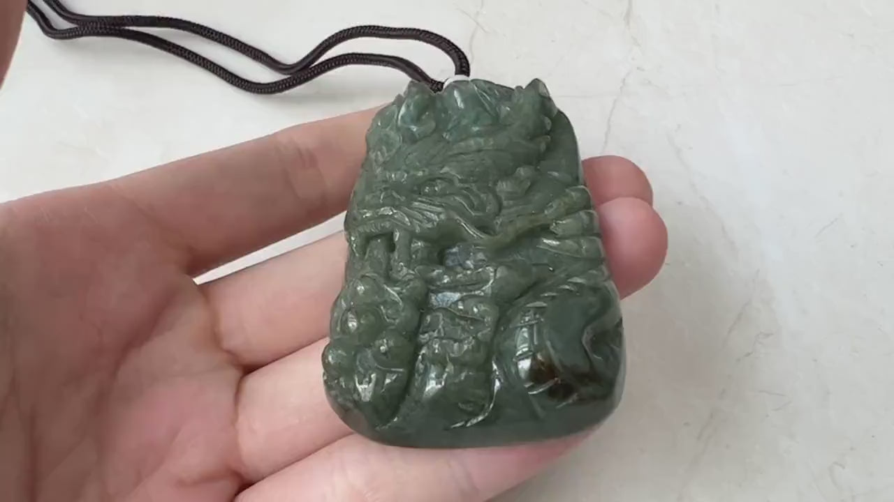 Video of a finely carved dragon pendant with detailed scales, claws, tail, and face in a striking statement style