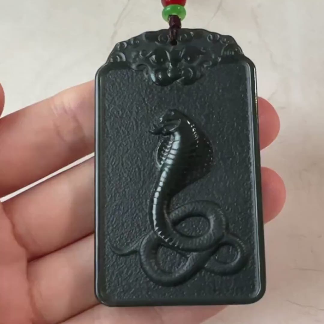 Video of hand-carved green jade Samantabhadra pendant with elephant and snake details, serene spiritual style