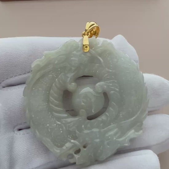 Video of a luminous green jade twin-dragon pendant with 18K gold bail, carved in a bold circular style