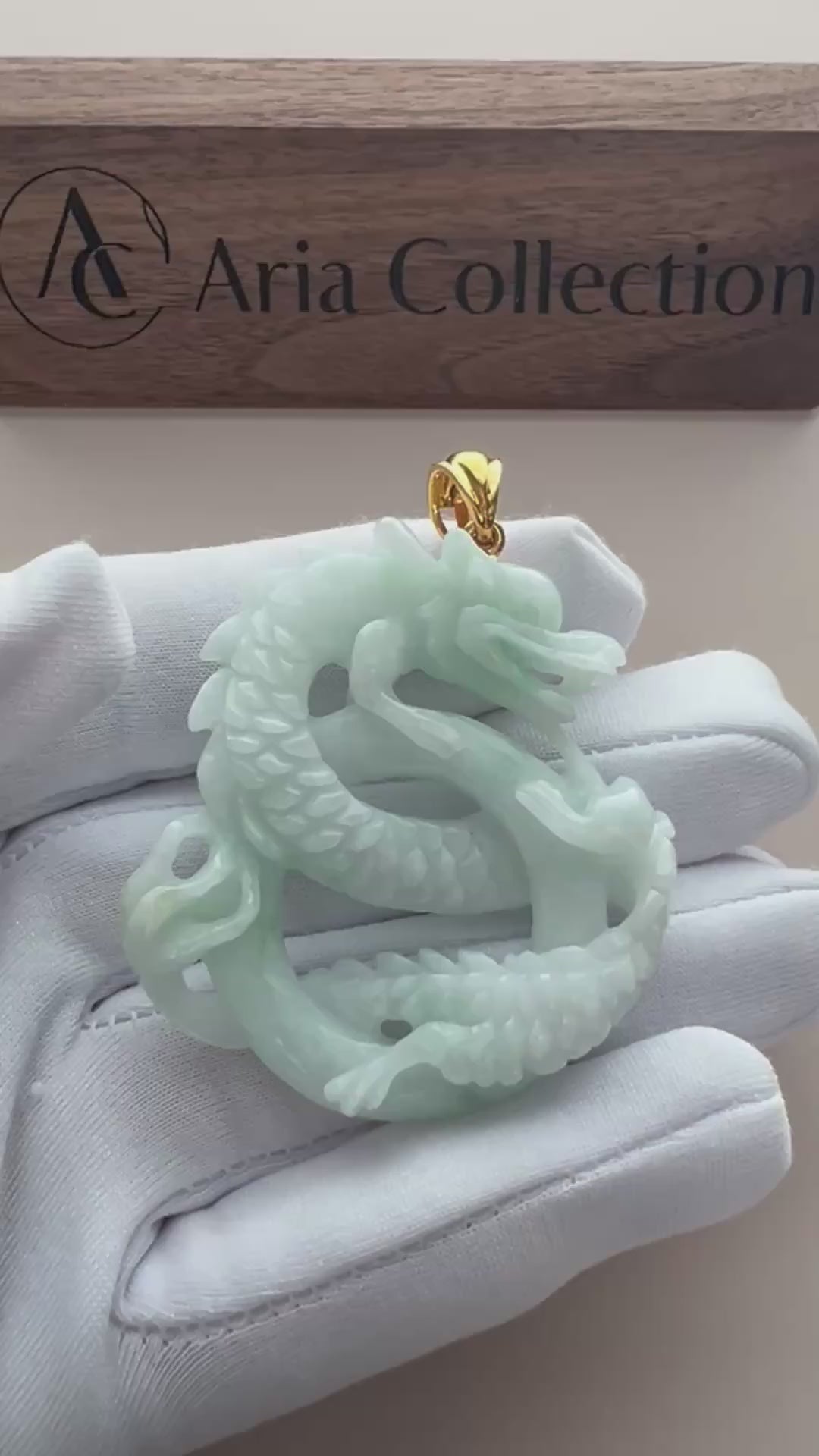 Video of pale mint-green natural jade double-dragon pendant with openwork carving and gold-tone bail