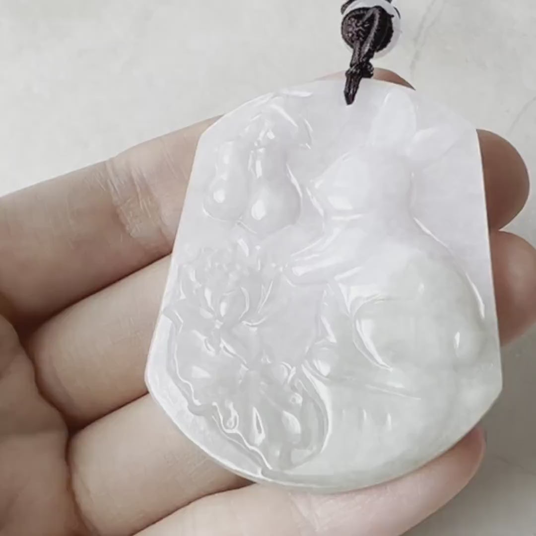 Video of a one-of-a-kind jadeite pendant carved as a rabbit with gourd and lotus, in green with detailed symbolic motifs