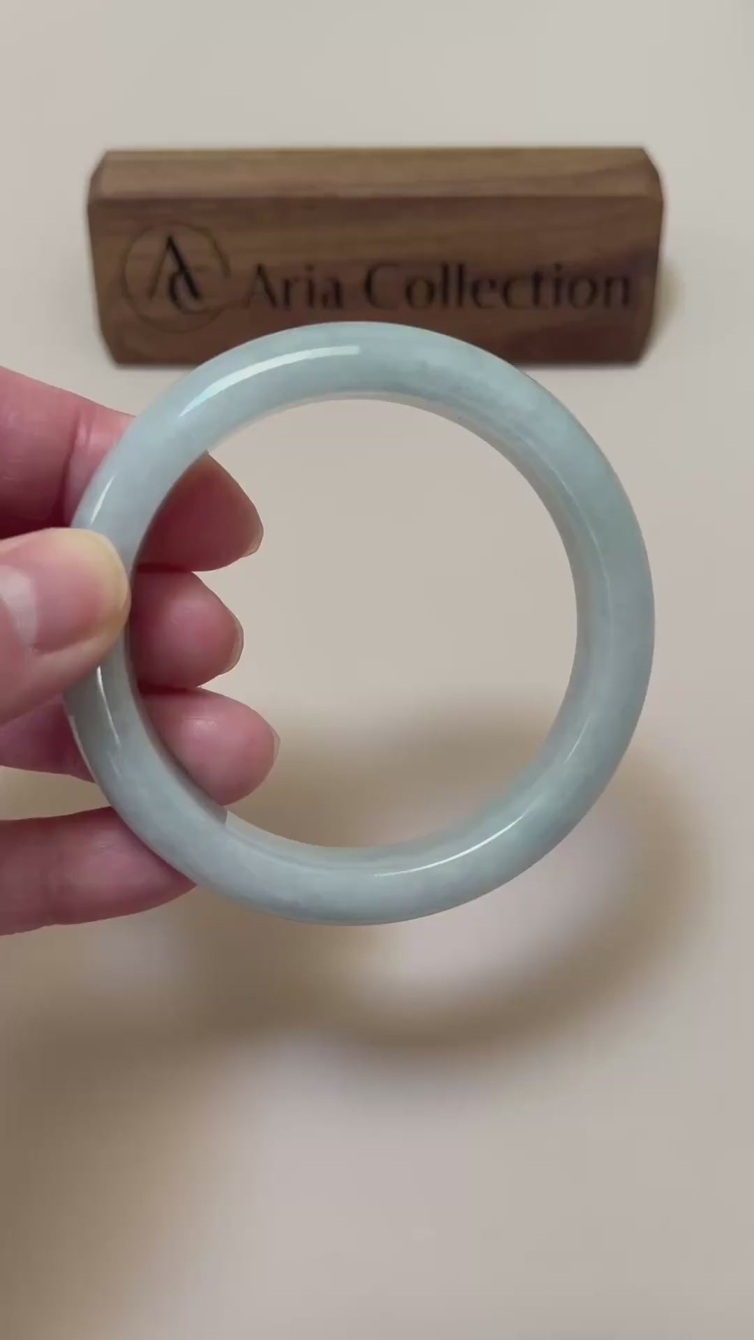 Video of a light blue Burmese jadeite bangle with cloudy variations, rounded profile, and high-polish finish