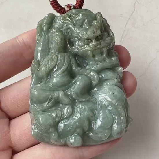 Video of a hand-carved green jade Guan Yin pendant with lotus and dragon, glowing in natural light