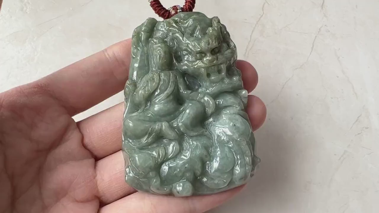 Video of a hand-carved green jade Guan Yin pendant with lotus and dragon, glowing in natural light