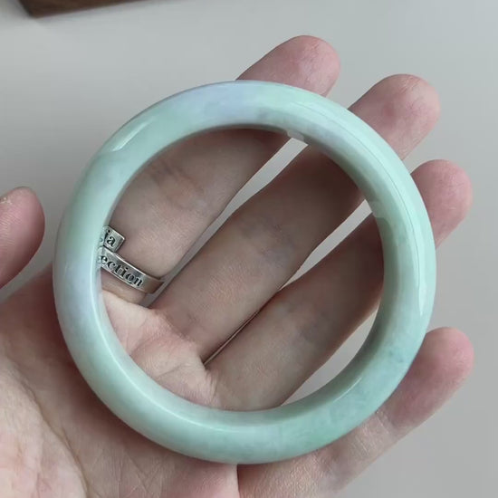 Video of a polished Burmese Type A jadeite bangle in light green-blue with soft mottling and a smooth rounded profile