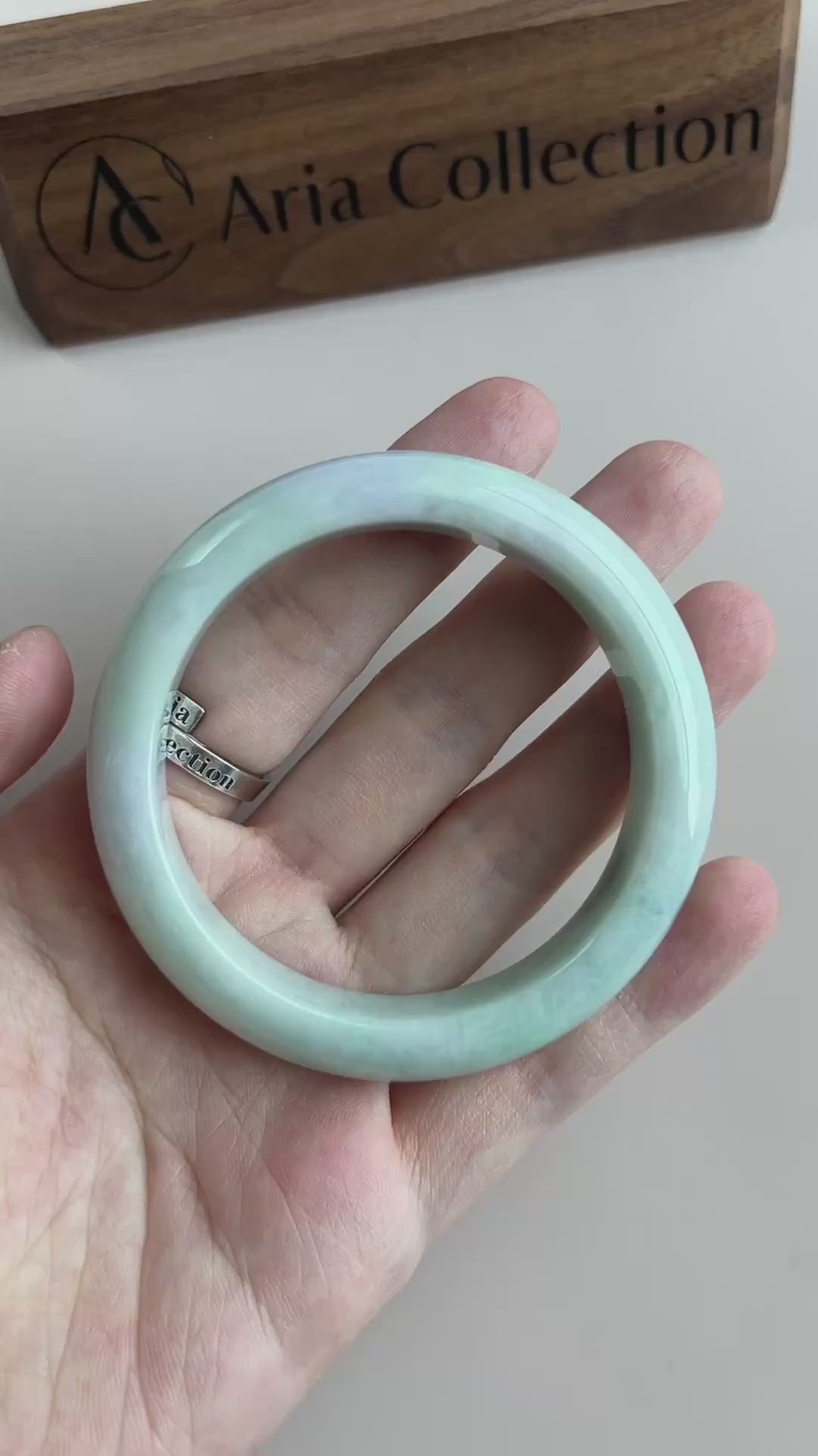 Video of a polished Burmese Type A jadeite bangle in light green-blue with soft mottling and a smooth rounded profile
