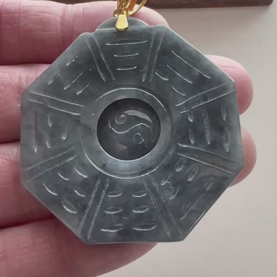 Video of an octagonal dark gray jade pendant with blue-green mottling, Ba Gua linework, Yin Yang center, and gold-tone bail