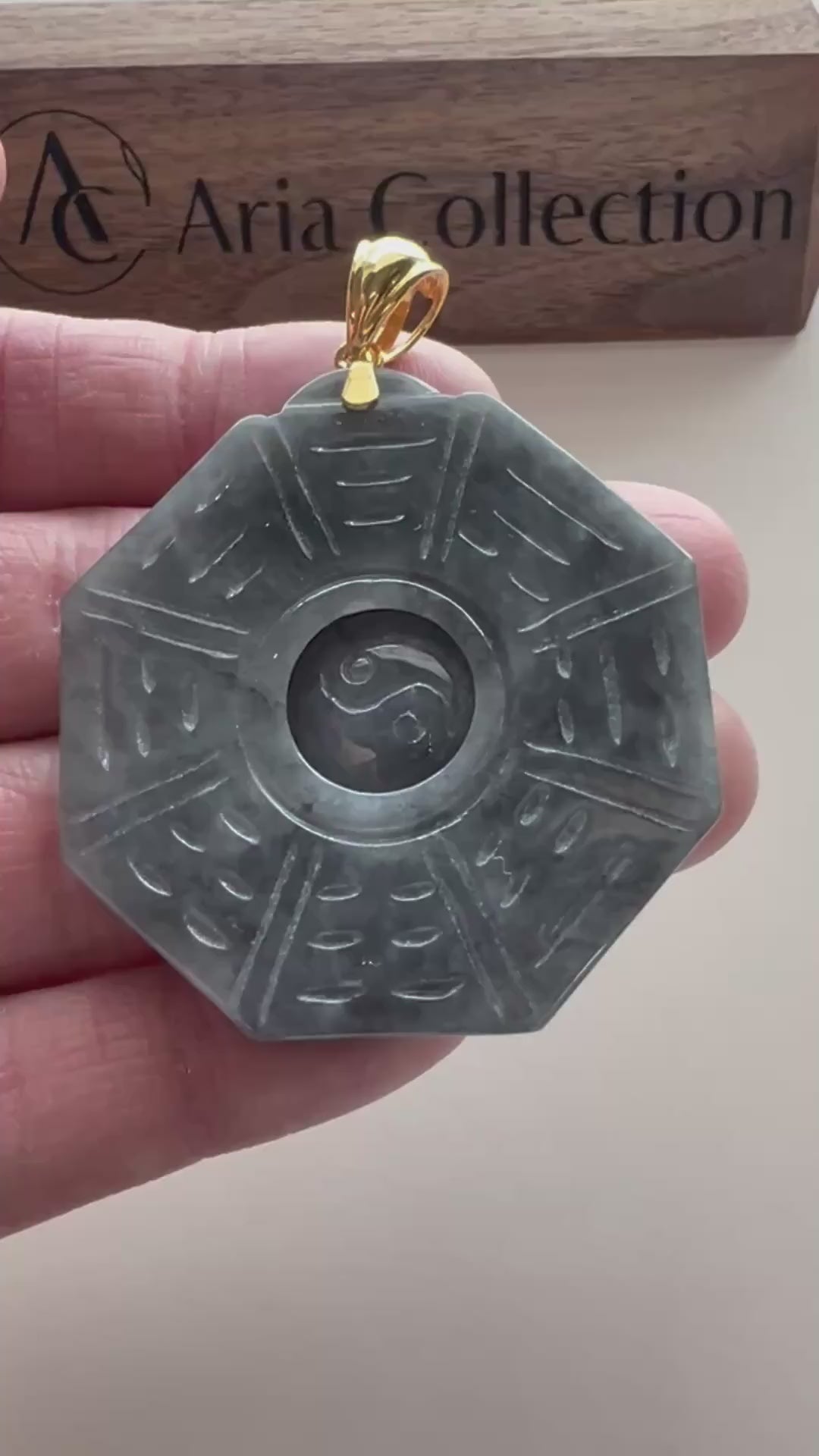 Video of an octagonal dark gray jade pendant with blue-green mottling, Ba Gua linework, Yin Yang center, and gold-tone bail