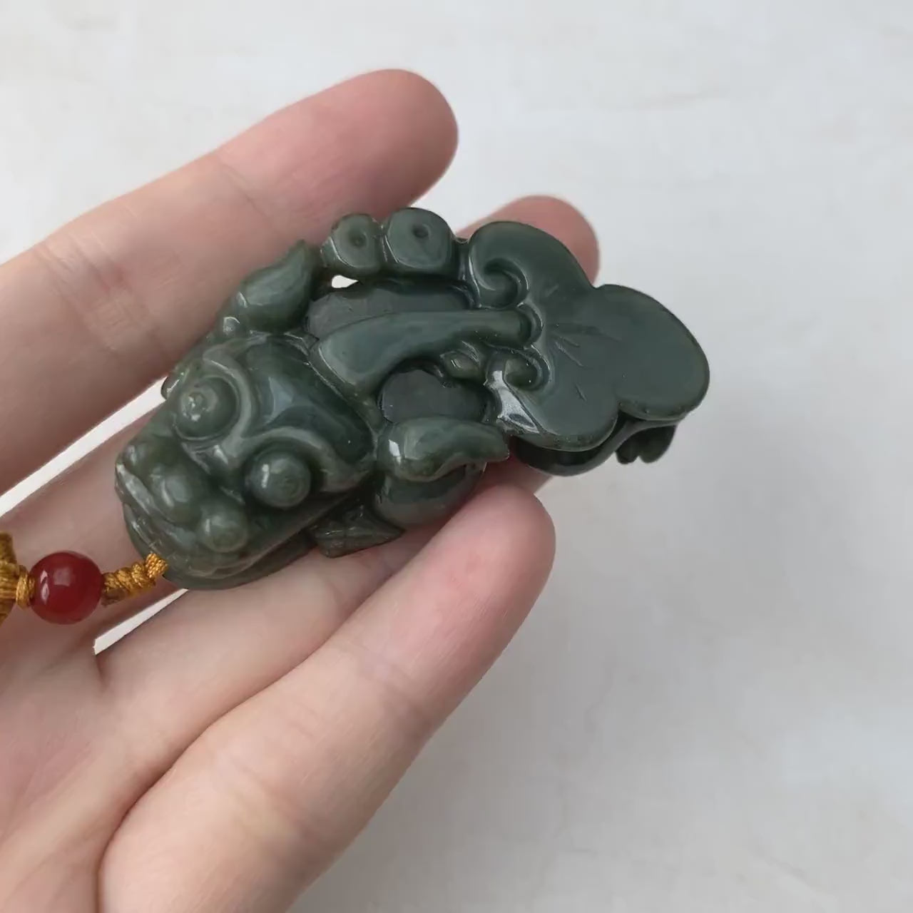 Video of a hand-carved dark green jadeite Pi Xiu pendant with rich tones and traditional auspicious style