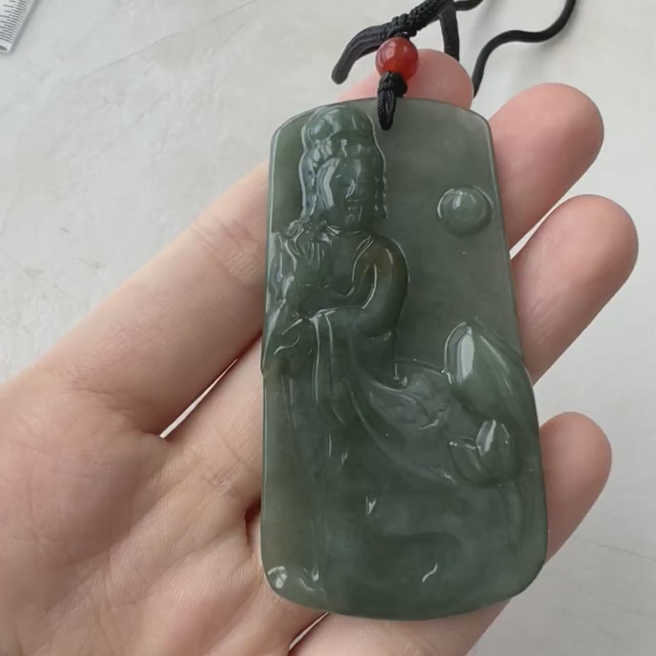 Video of a hand-carved natural jade Guan Yin pendant with serene details and timeless elegant style