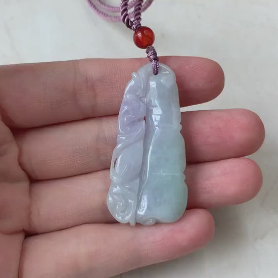 Video of hand-carved jadeite pendant with bamboo and bat motif, rich green and lavender tones, semi-translucent glow
