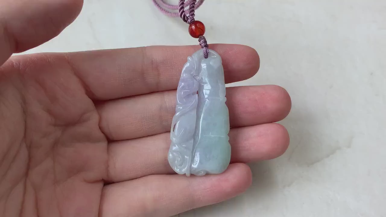 Video of hand-carved jadeite pendant with bamboo and bat motif, rich green and lavender tones, semi-translucent glow