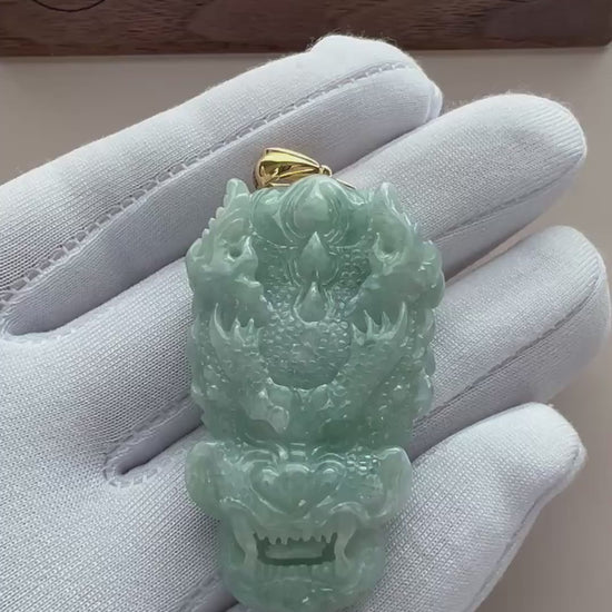 Video of a light green translucent jade dragon pendant with carved scales and gold-tone bail
