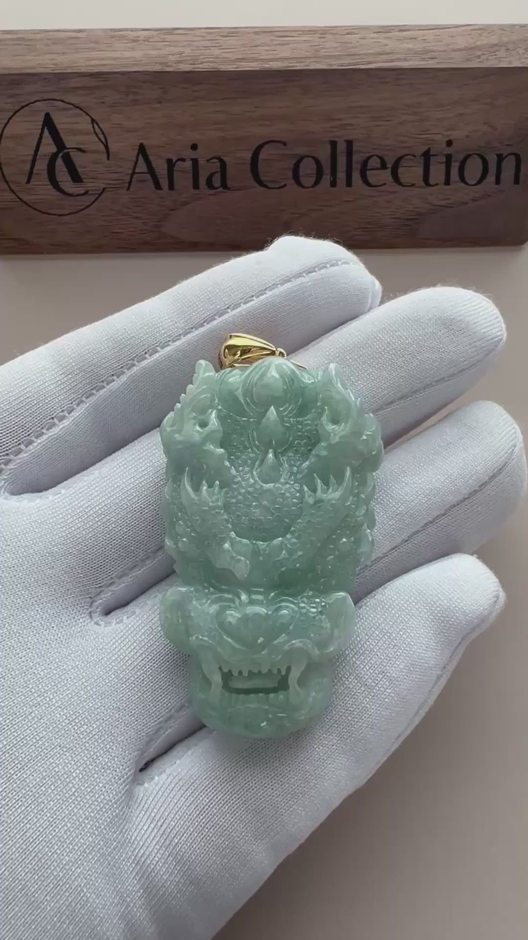 Video of a light green translucent jade dragon pendant with carved scales and gold-tone bail