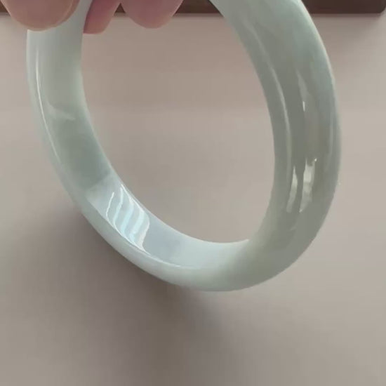 Video of a classic Burmese Type A jadeite bangle in icy light green-blue with a smooth, high-polish rounded profile