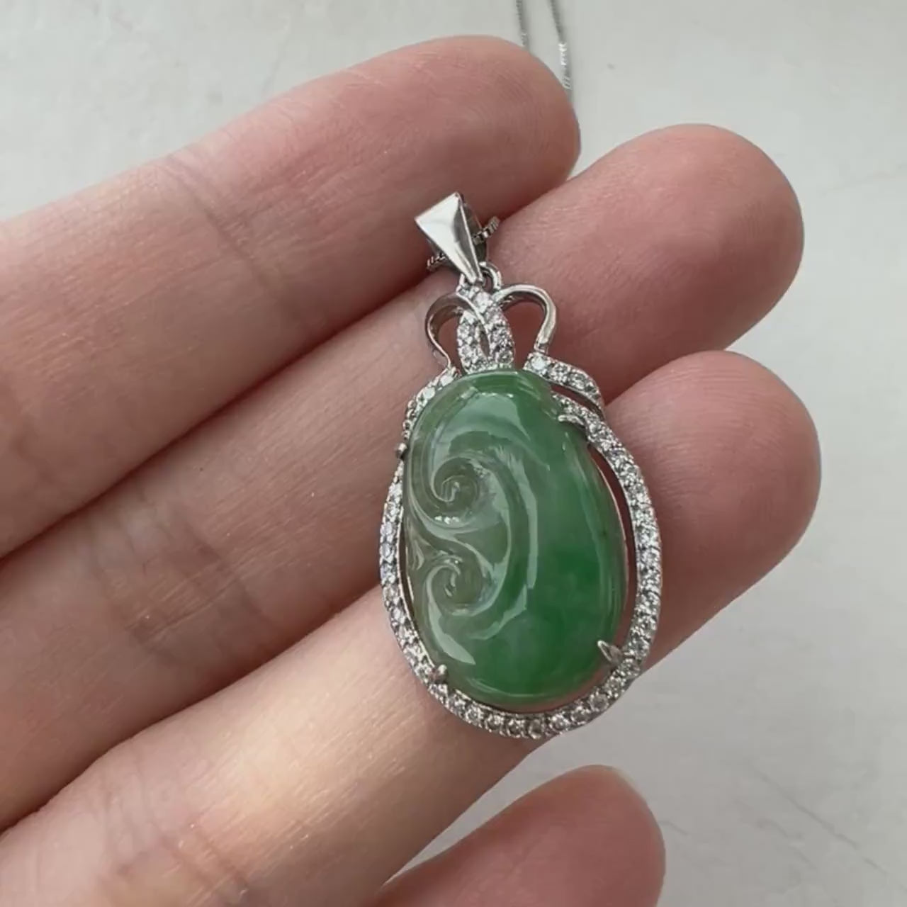 Video of a bright green natural jadeite Ruyi pendant framed in sterling silver, with a refined traditional design