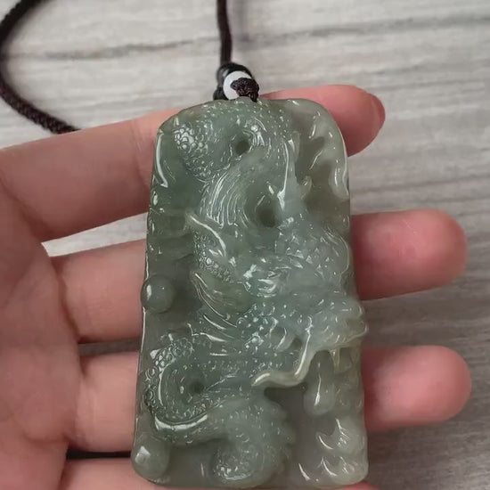 Video of a hand-carved natural jadeite jade dragon pendant with detailed scales, claws, and Ruyi tail design