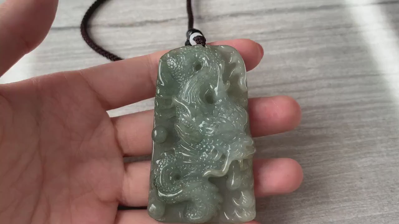 Video of a hand-carved natural jadeite jade dragon pendant with detailed scales, claws, and Ruyi tail design