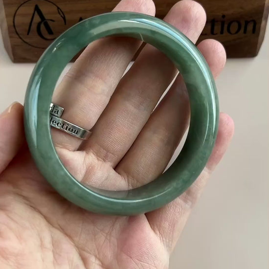 Video of a classic Burmese Type A jadeite bangle in rich dark green with semi-translucent, high-polish smooth rounded design