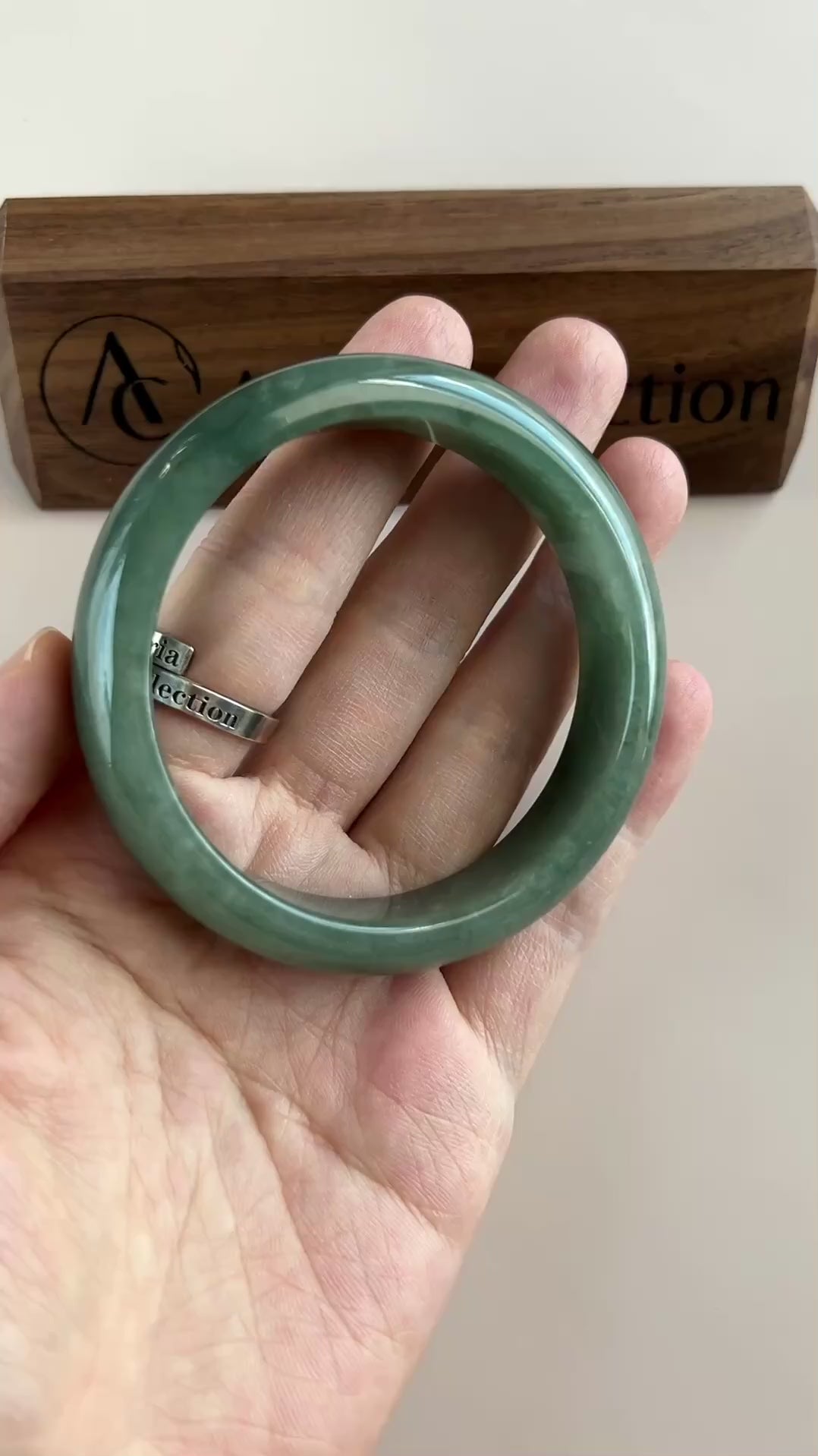 Video of a classic Burmese Type A jadeite bangle in rich dark green with semi-translucent, high-polish smooth rounded design