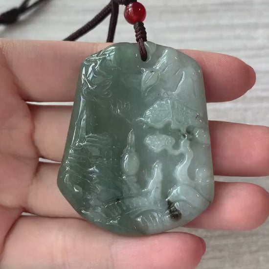 Video of a hand-carved green jade pendant with serene mountain, forest, bridge, and house details