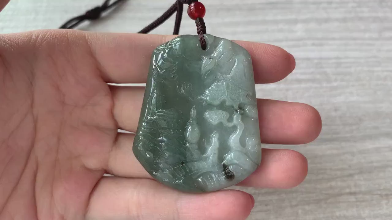 Video of a hand-carved green jade pendant with serene mountain, forest, bridge, and house details