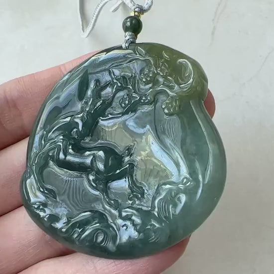 Video of hand-carved dark-green jade pendant with deer beneath a tree, elegant traditional design
