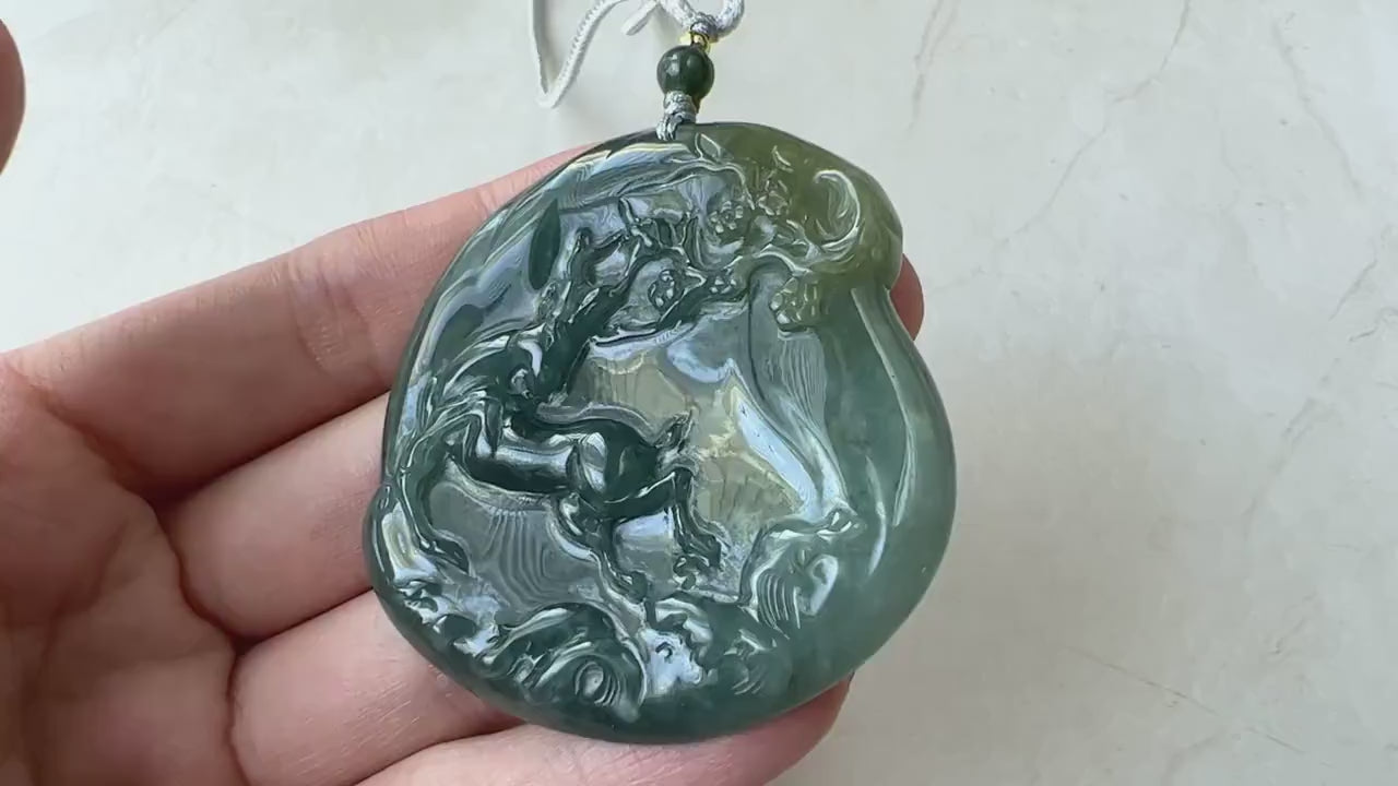 Video of hand-carved dark-green jade pendant with deer beneath a tree, elegant traditional design