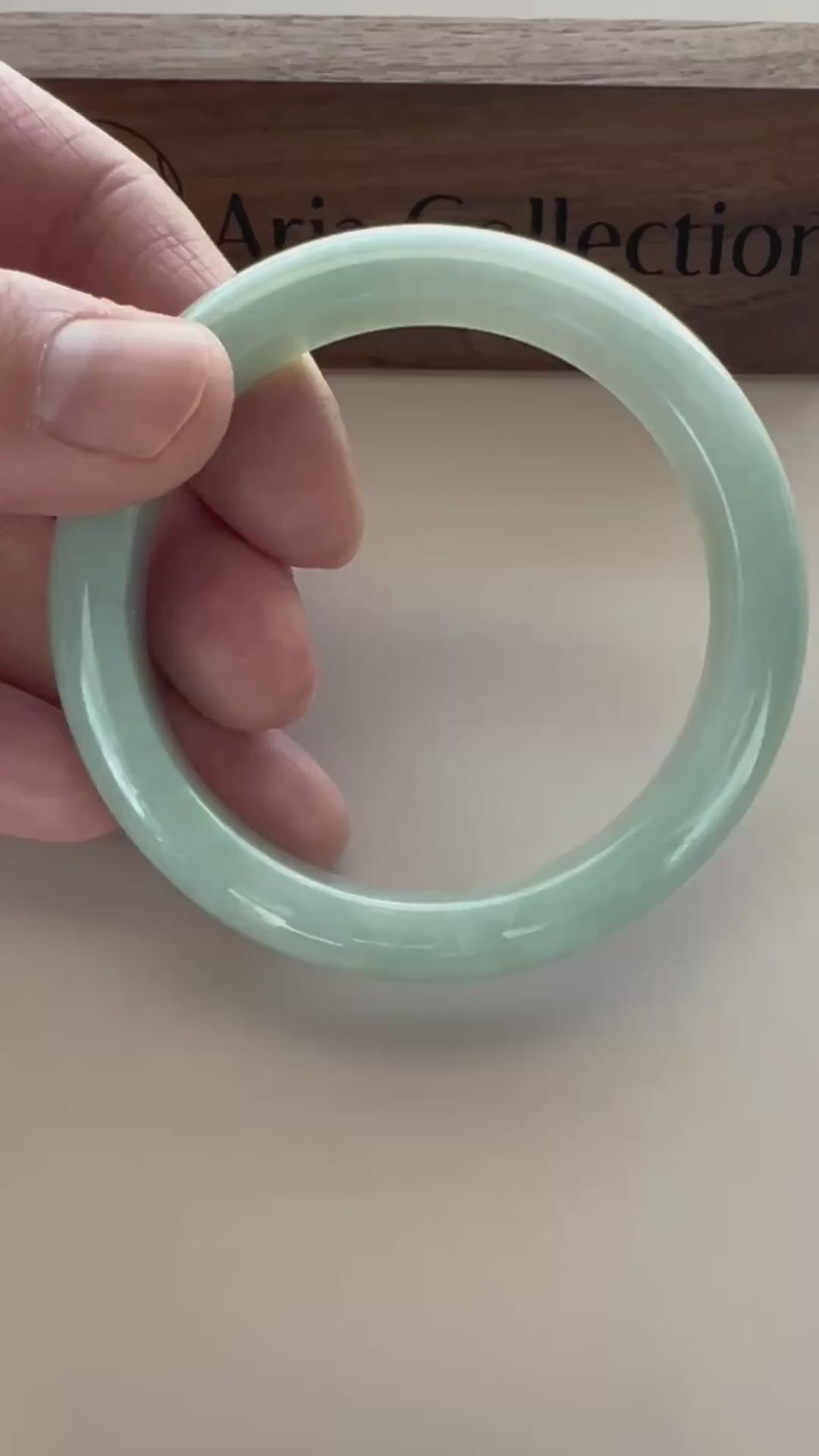 Video of a polished Burmese Type A jadeite bangle in soft light green-blue with carved grooves and subtle translucency