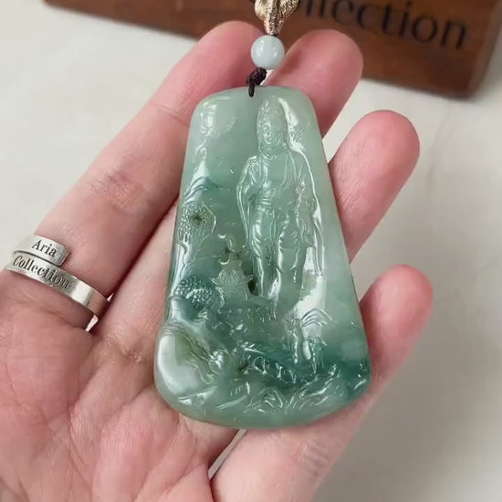 Video of a hand-carved jadeite jade Guan Yin pendant with serene mountain scene and intricate detail