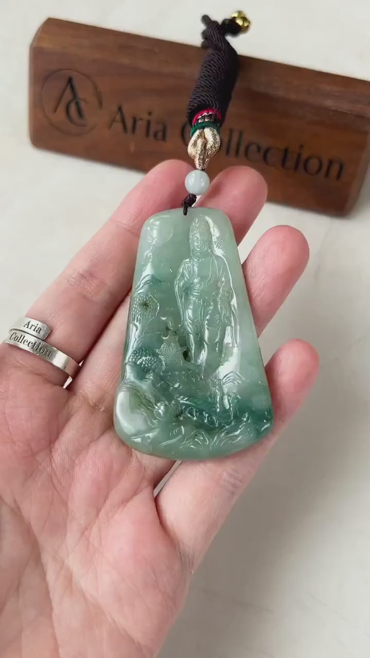 Video of a hand-carved jadeite jade Guan Yin pendant with serene mountain scene and intricate detail