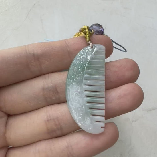 Video of a hand-carved light green semi-translucent natural jadeite comb charm with a smooth decorative finish