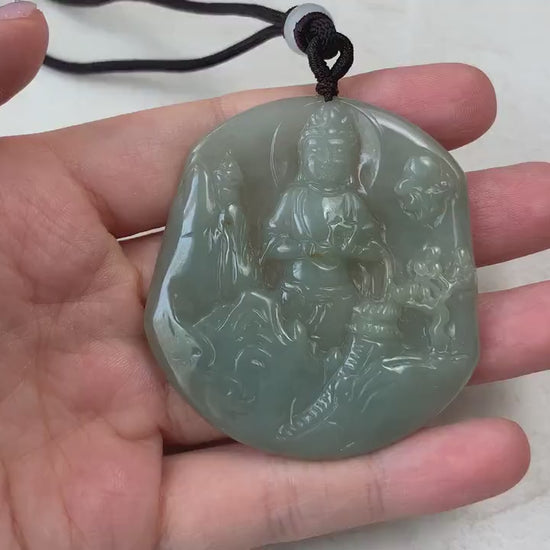 Video of a hand-carved natural jade Guan Yin pendant with serene mountain landscape details in green jade