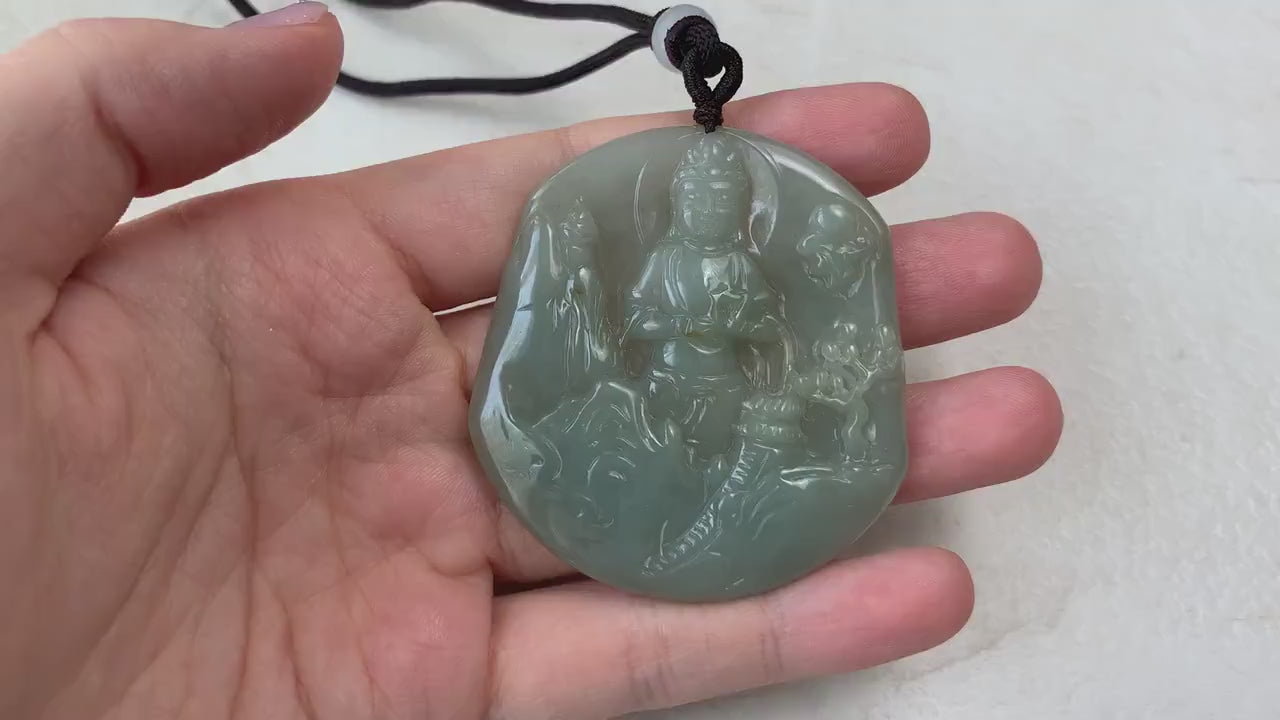 Video of a hand-carved natural jade Guan Yin pendant with serene mountain landscape details in green jade