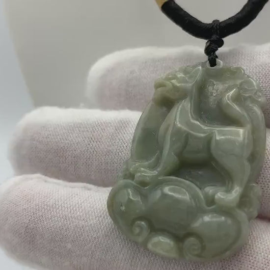 Video of hand-carved natural jade pendant in Chinese Zodiac Dog form, unique green stone with artisanal detail