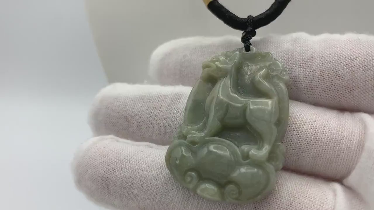 Video of hand-carved natural jade pendant in Chinese Zodiac Dog form, unique green stone with artisanal detail
