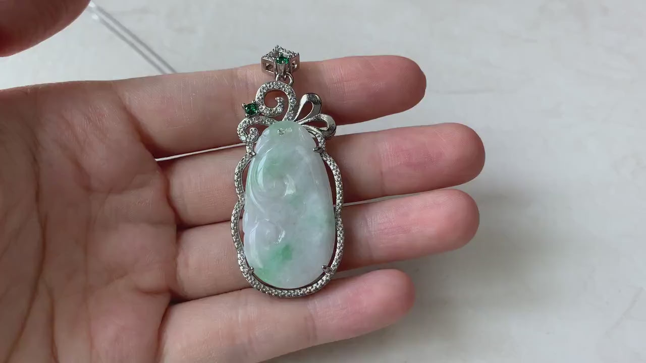 Video of a hand-carved milky white jadeite Ruyi pendant with green highlights in an elegant sterling silver setting