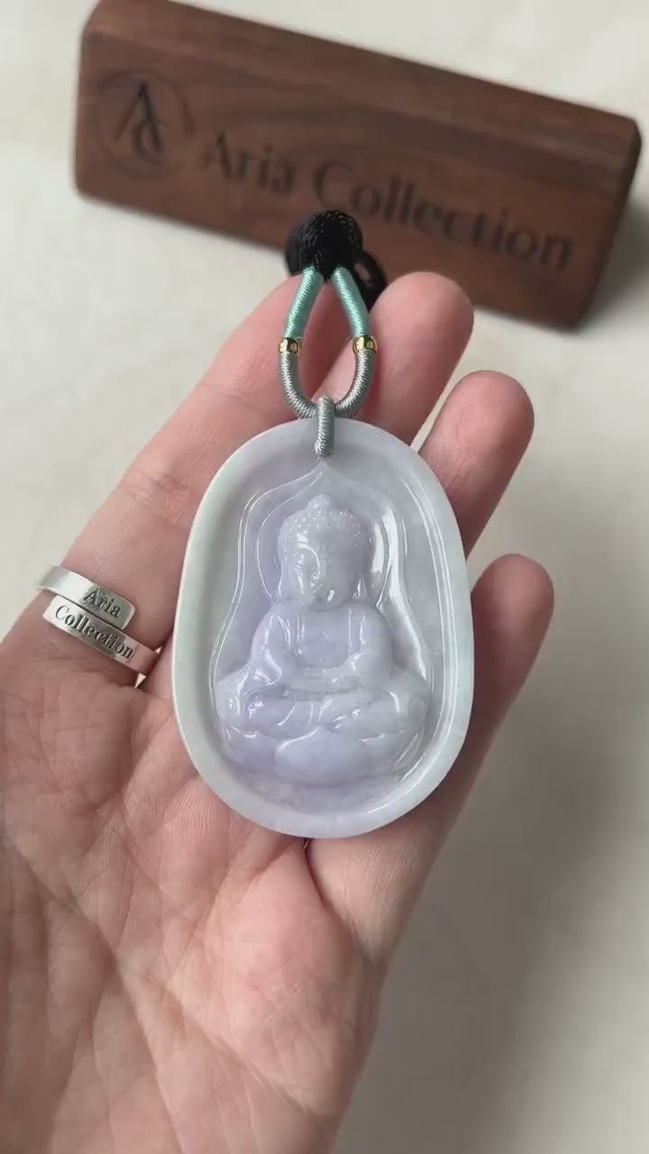 Video of hand-carved pendant with serene Baby Buddha on lotus, intricate details, symbolic and elegant style